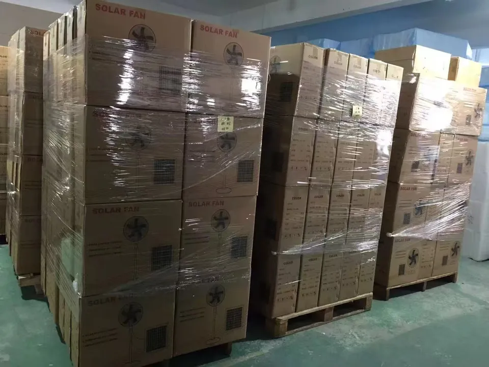 Fan cartons stacked on wooden pallets and secured with transparent stretch wrap.