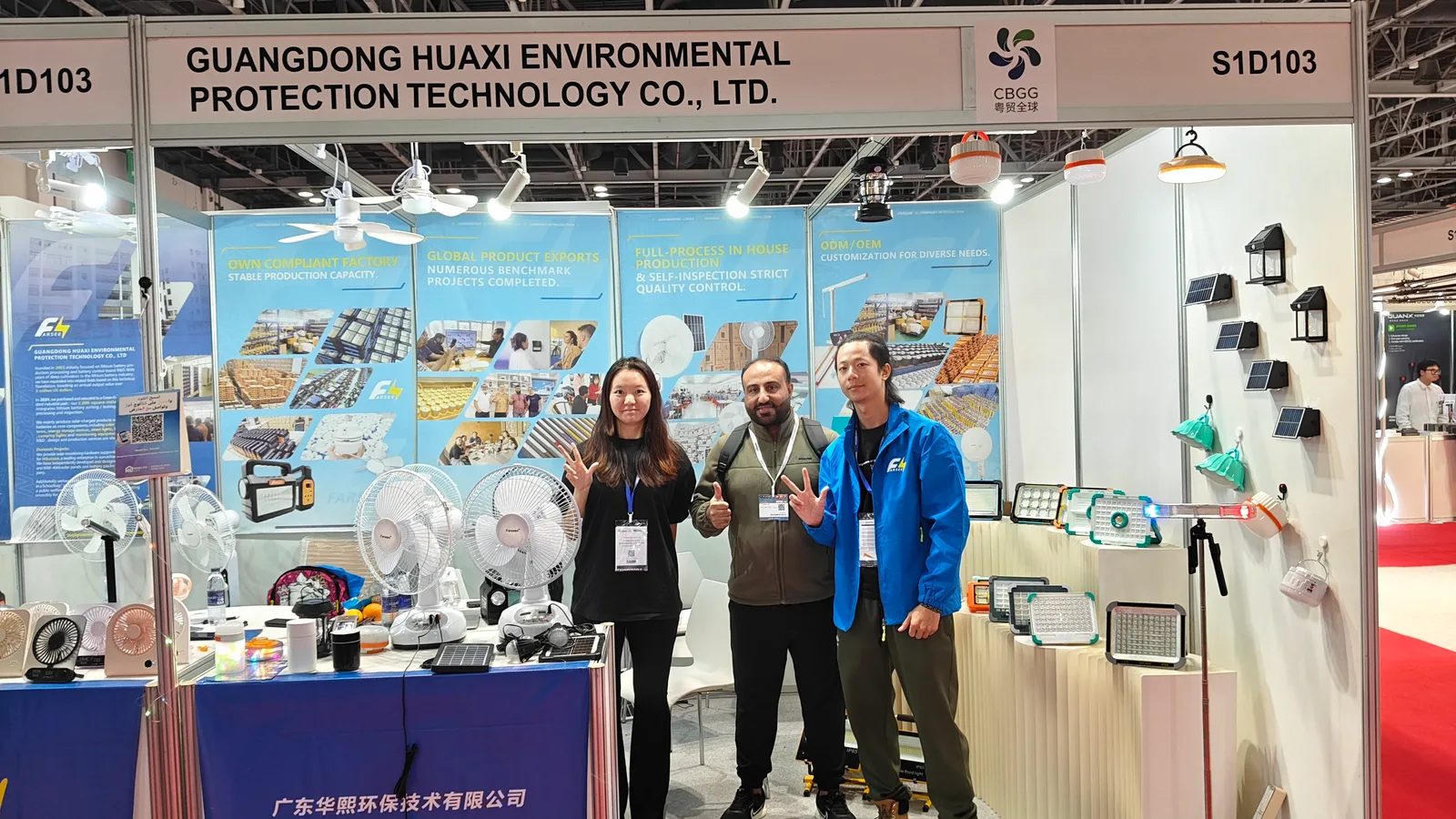 Farseen team with a visitor at booth S1D103 in Dubai, surrounded by fans and lighting products