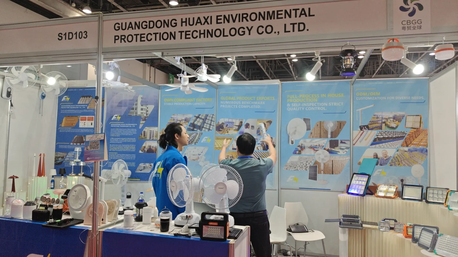 Visitors viewing the Farseen booth display, with table fans, portable lights and floodlights in the foreground
