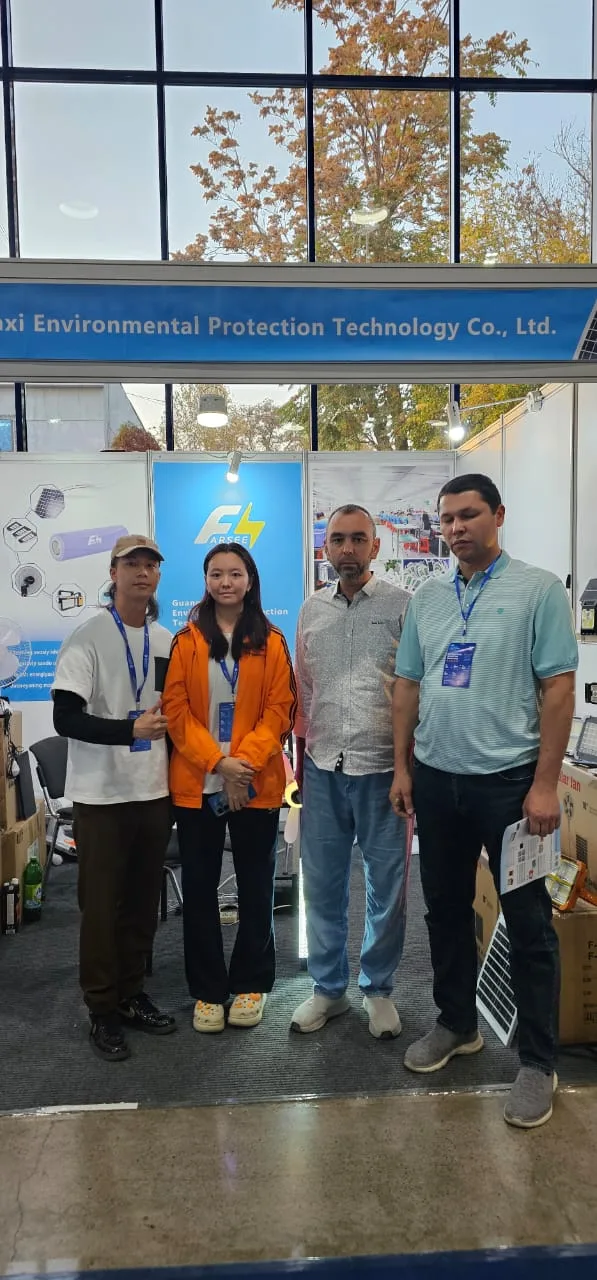 Farseen team and visitors at the exhibition booth in Uzbekistan, with a solar panel and product displays